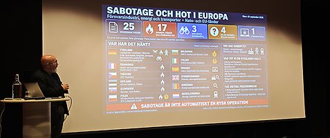 Föreläsare Patrik Oksanen tittar på skärmen medan han föreläser.