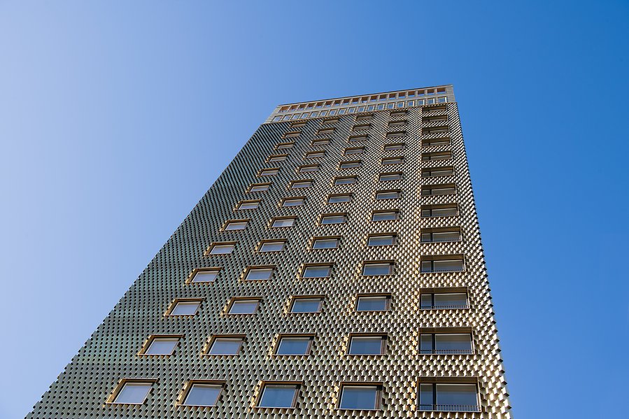 Guldfärgad skyskrapa och blå himmel i bakgrunden